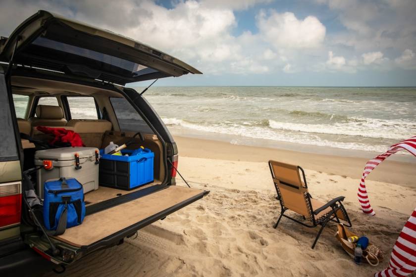 car on beach filled with coolers and beach gear